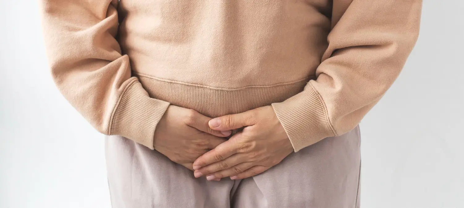 Frauenarztpraxis-Faur - Gynäkologie und Geburtshilfe - Eine Person hält sich mit beiden Händen den Unterbauch.